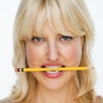 Woman Biting Pencil --- Image by © Tom Grill/Corbis